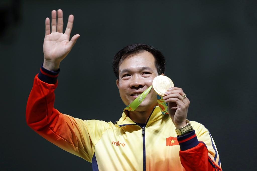 Hoang Xuan Vinh of Vietnam celebrates with his gold medal on the podium after winning the men's 10m